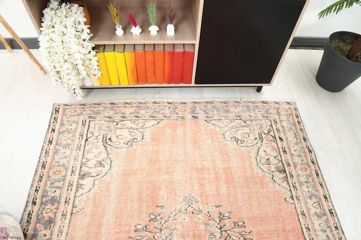 Angled view focusing on the upper portion of the orange rug, showing the field and border design