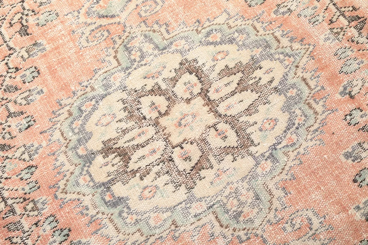 Close-up detail of the central medallion pattern, showing beige, gray, and brown tones