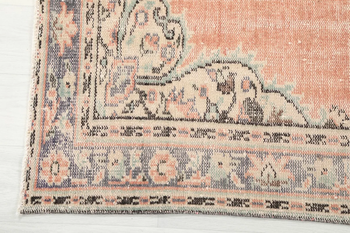 Detailed view of the rug's corner and border design, showcasing navy, beige, and gray elements