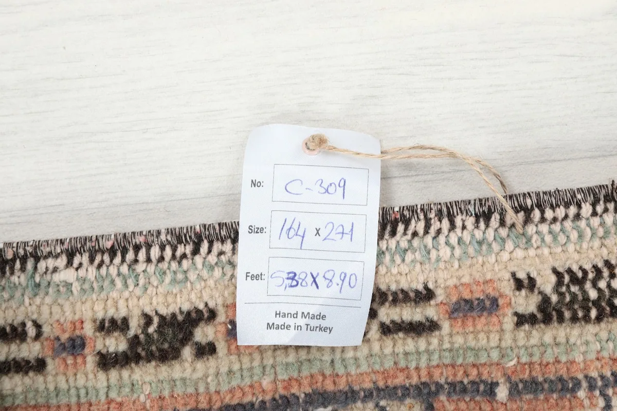 Tag displaying the rug's size in centimeters and feet, and confirming it is hand made in Turkey