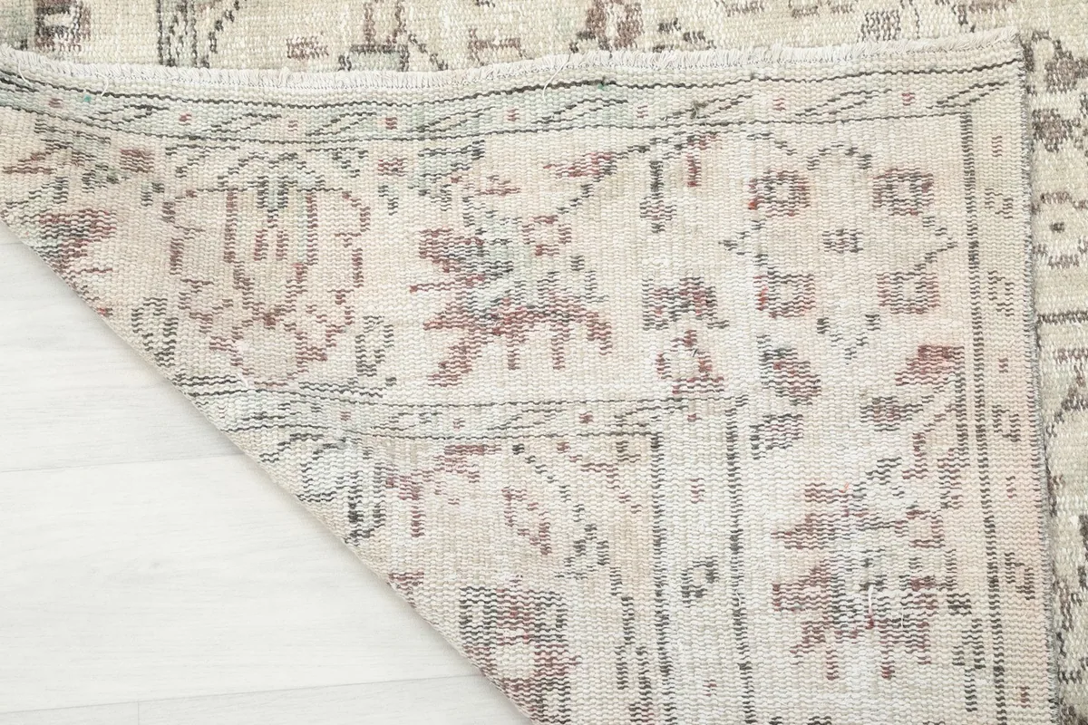 Close-up of the rug's reverse side, revealing the hand-knotted cotton foundation and wool pile.