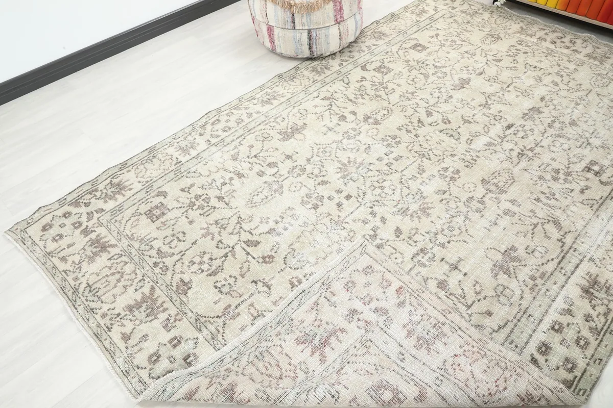 View of a corner of the rug folded back, showing the reverse side and construction.