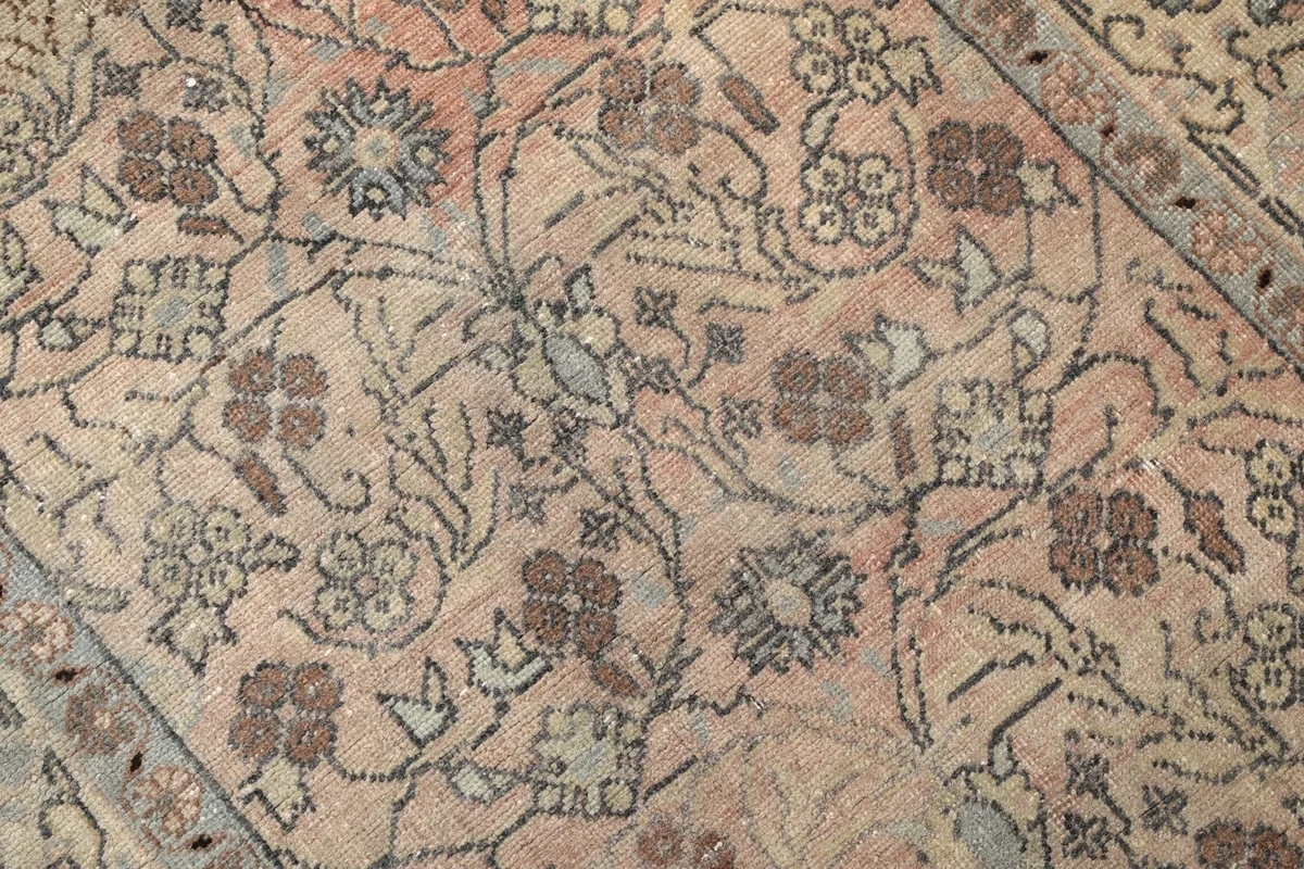 Close-up of the hand-knotted wool pile, revealing the intricate floral patterns and color variations.