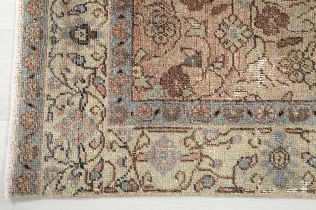 Corner detail showing the intricate design of the ivory border and its transition to the rose field.