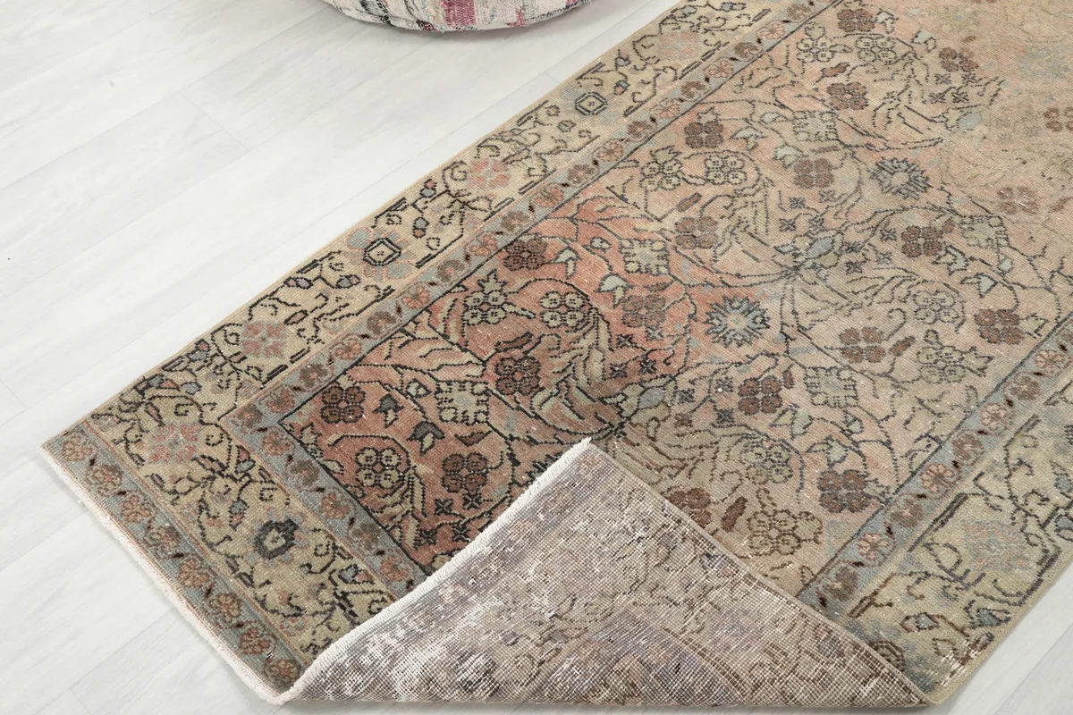 The rug partially folded, showing the soft wool pile and the reverse side.