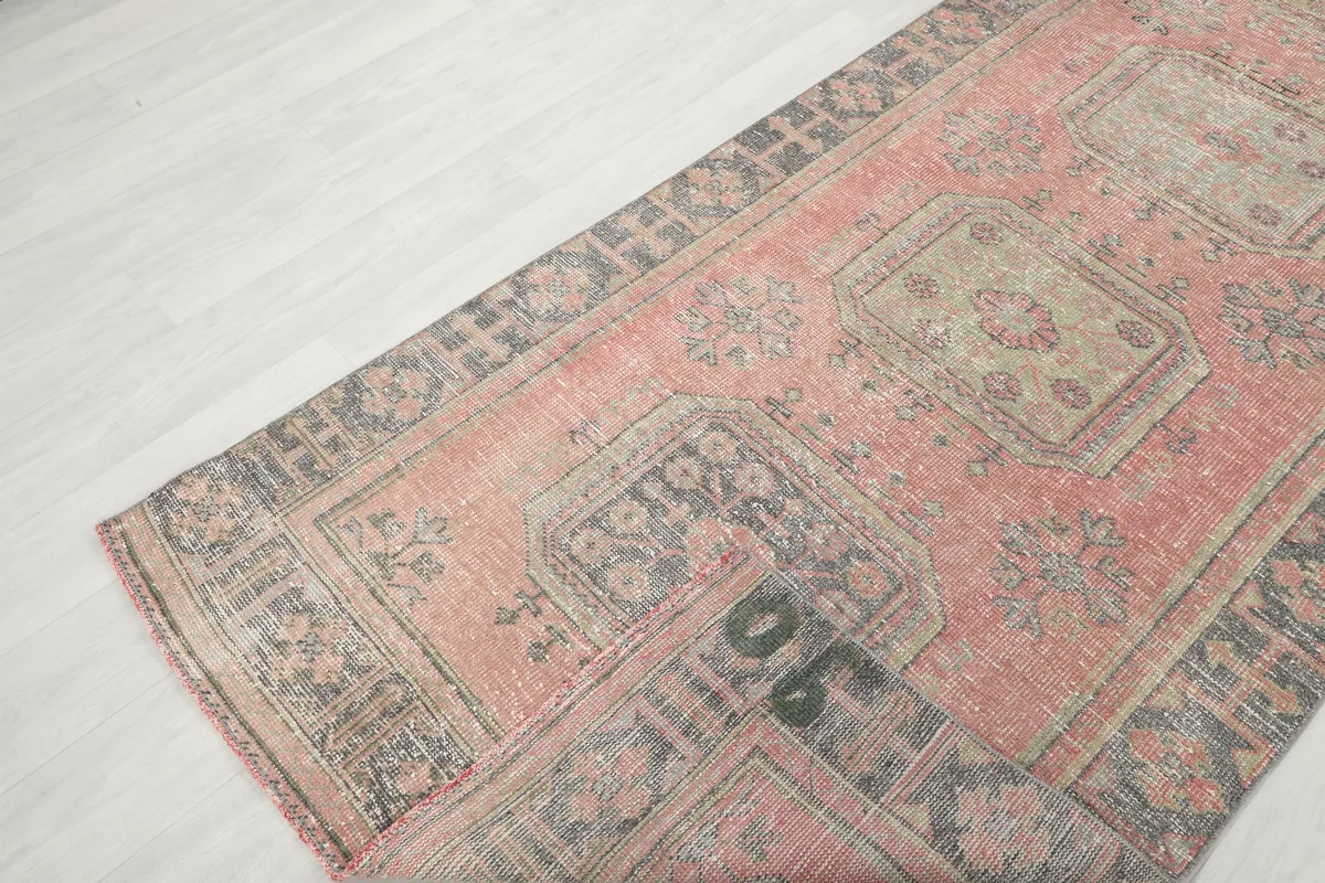 Faded Rose Geometric Anatolian Runner with a corner folded to show the back and weave structure.
