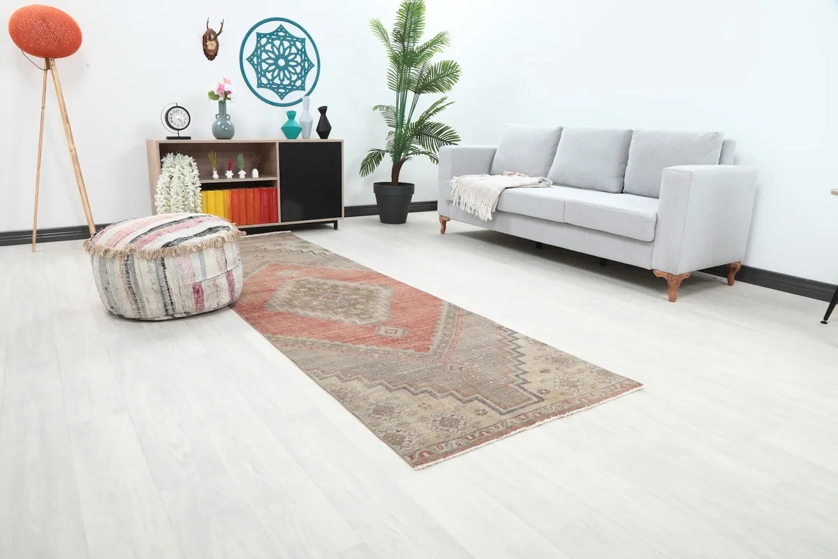 Angled view of the rust and beige runner rug in a room, highlighting its length and design flow.
