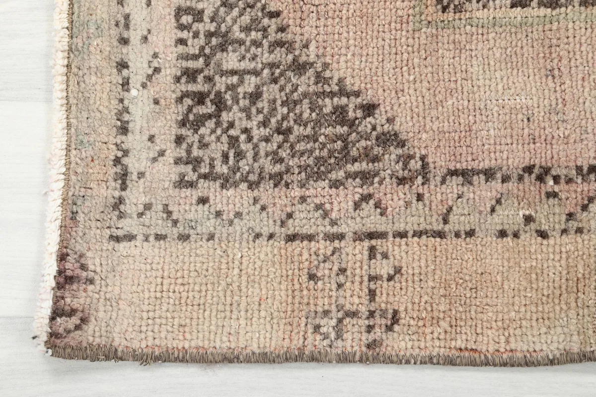 Close-up of the rug's edge, showing the border design and hand-knotted fringe.