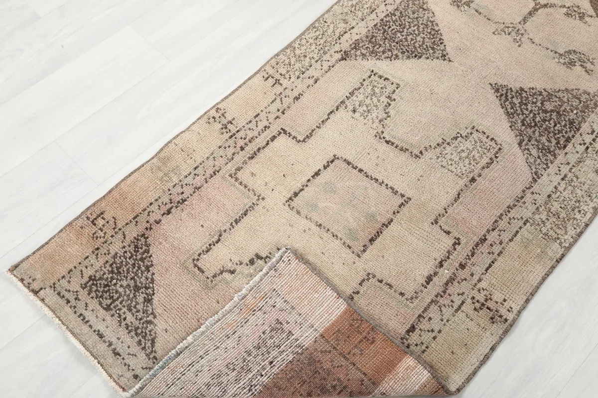 Runner rug partially folded, showcasing the design and the low pile height.