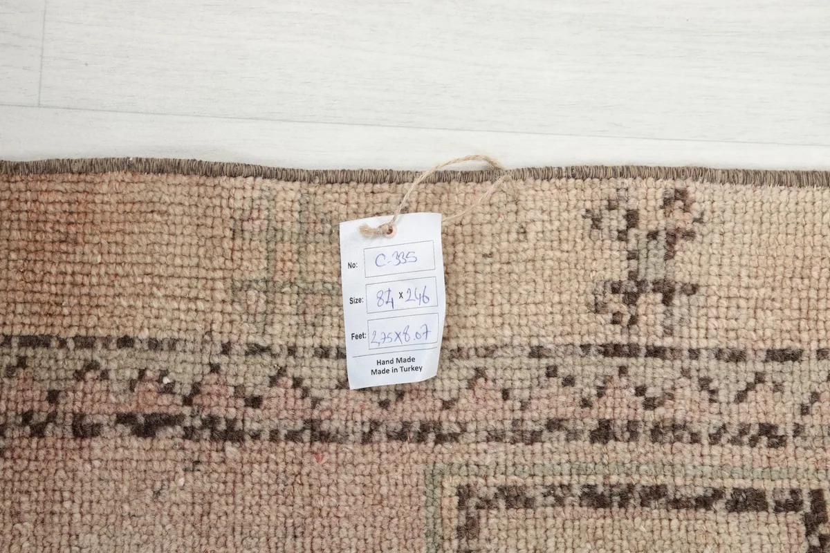 Close-up of the rug's corner with a tag showing the size 84x246 cm.