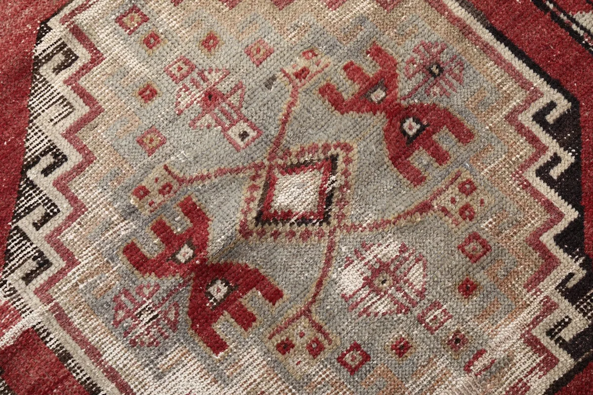 Close-up of the intricate tribal symbols and geometric patterns within the rug's central design