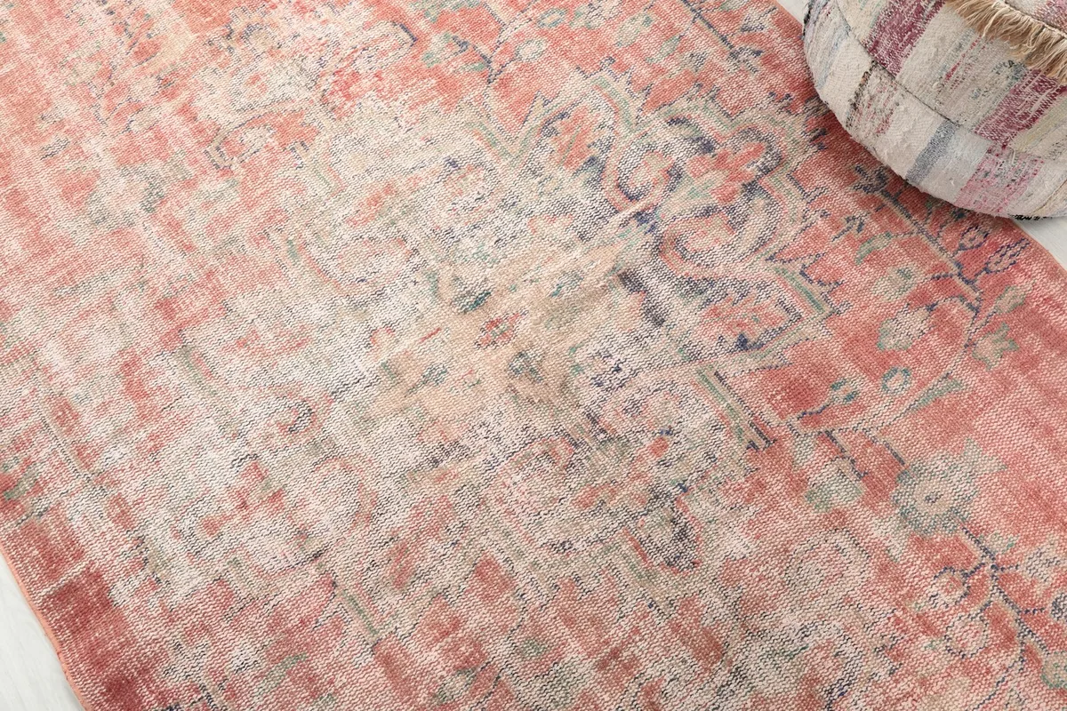 Close-up detail of the distressed wool pile and subtle blue and beige patterns.