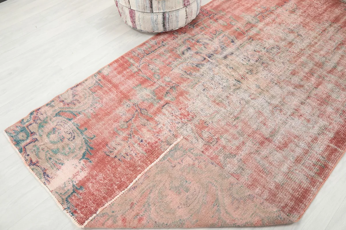 Folded corner of the rug revealing the cotton foundation and the back of the hand-knotted wool.
