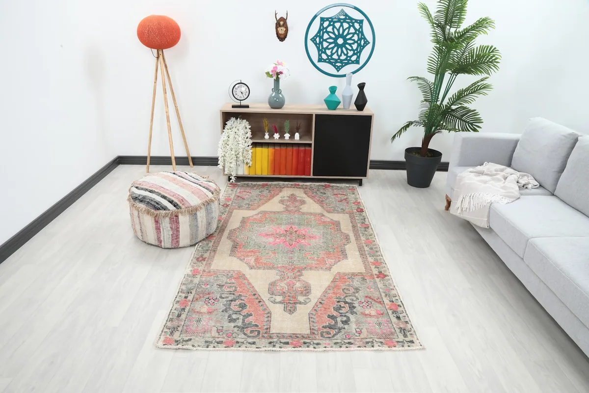 Vintage Anatolian rug displayed in a modern living room setting with a light grey couch and wooden furniture.