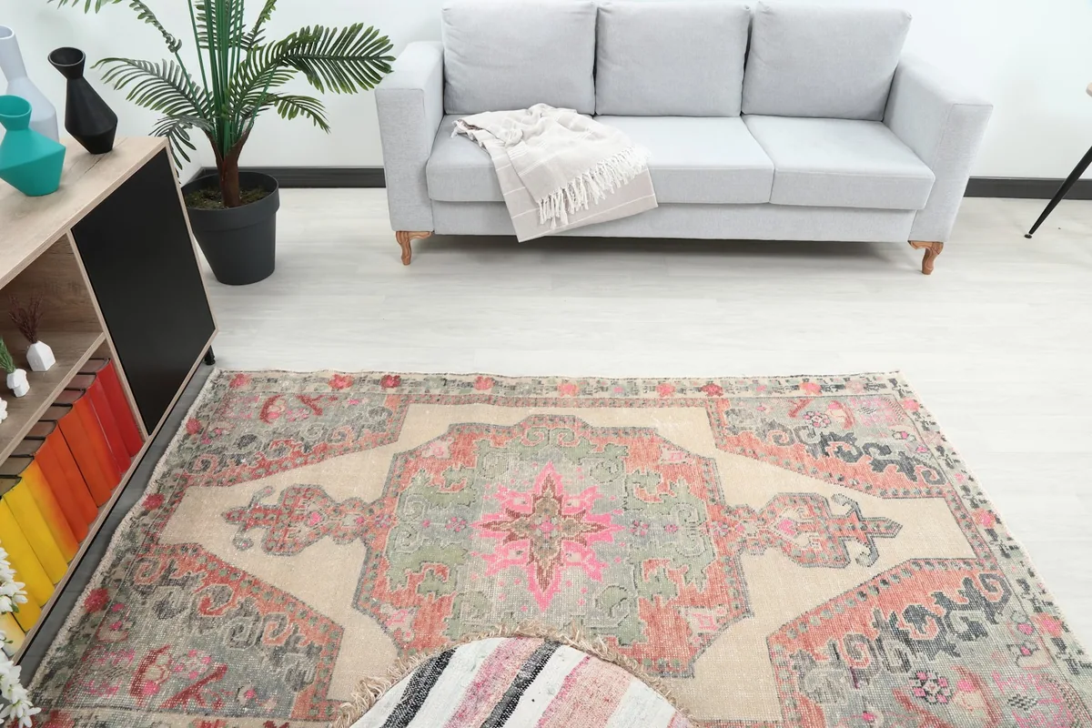 Overhead view showing the rug's full pattern and colors in the context of a room with a sofa.