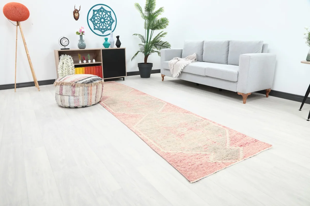 Angle view of the rose and gray runner rug extending through a hallway in a home decor setting.