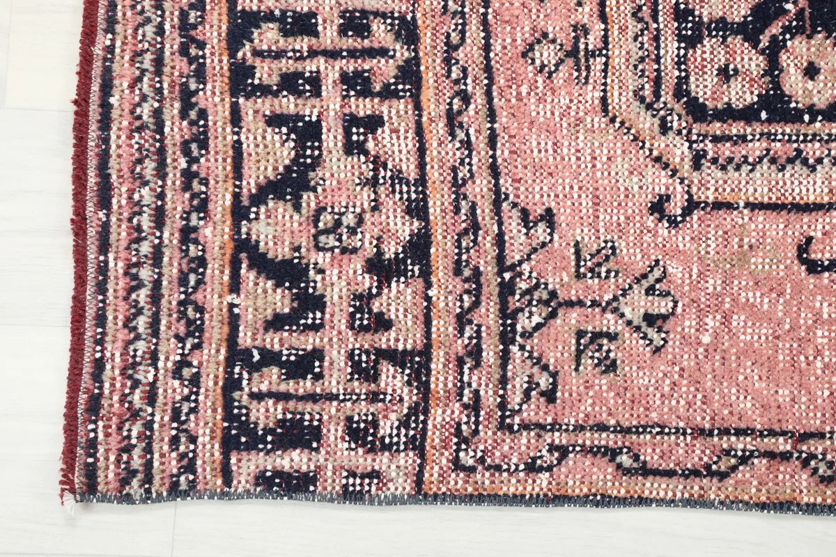 Close-up of the navy geometric border and rose field, showing the edge finishing