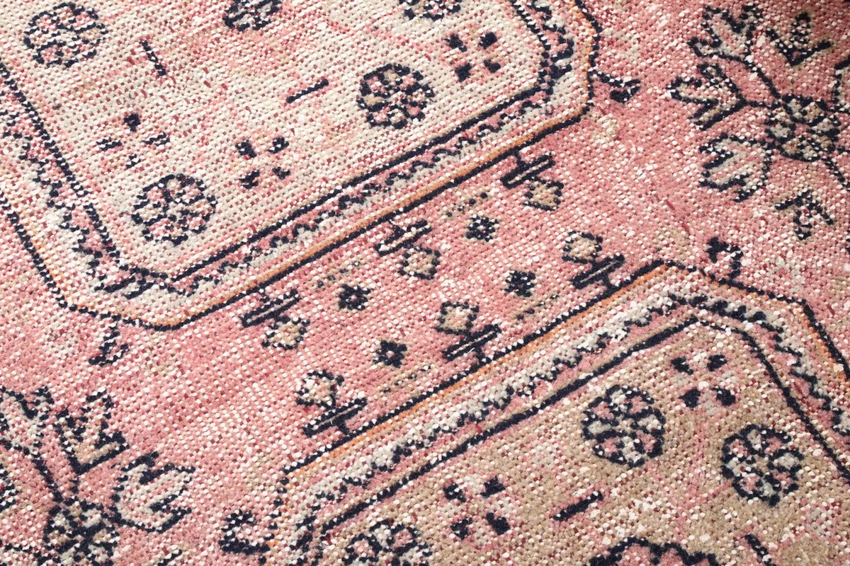 Detailed view of the low wool pile and intricate hand-knotted geometric design