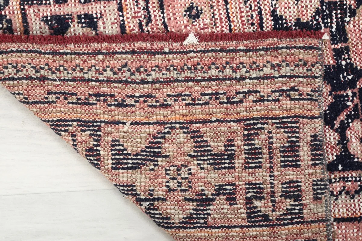 Close-up of the rug's back, revealing the hand-knotted cotton foundation and wool knots