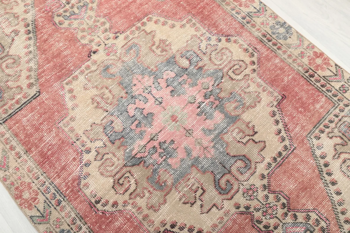 Detailed close-up of the central medallion with rose, blue, and beige tones