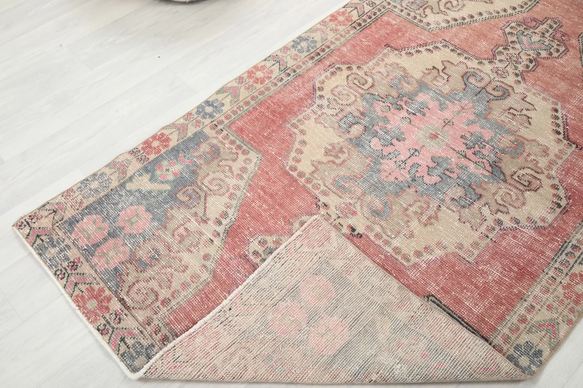 Corner of the rug folded back to reveal the cotton foundation and reverse side of the knots