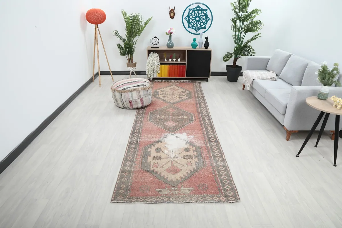 Vintage runner rug displayed in a modern hallway with a gray sofa and decor