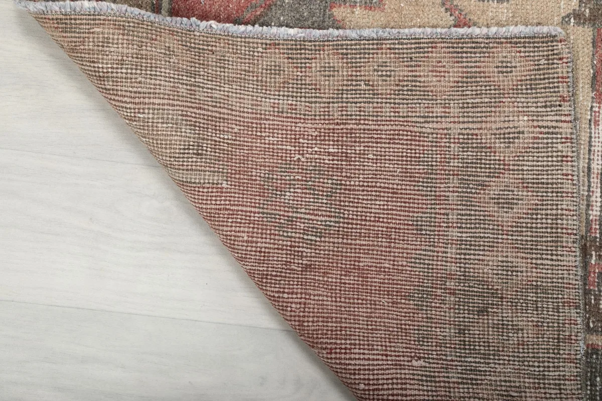 Underside view of the rug, revealing the hand-knotted cotton foundation