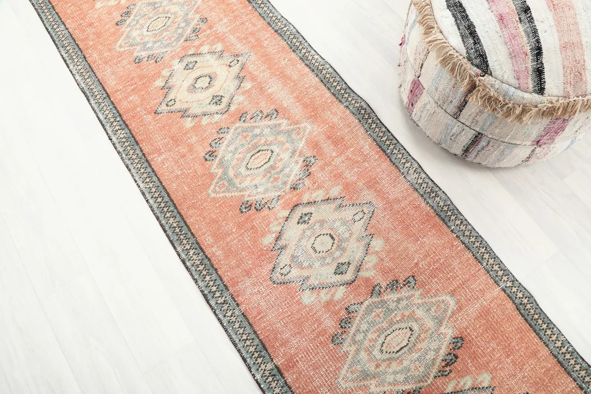 Angled view of the runner rug, highlighting the repeating geometric diamond patterns