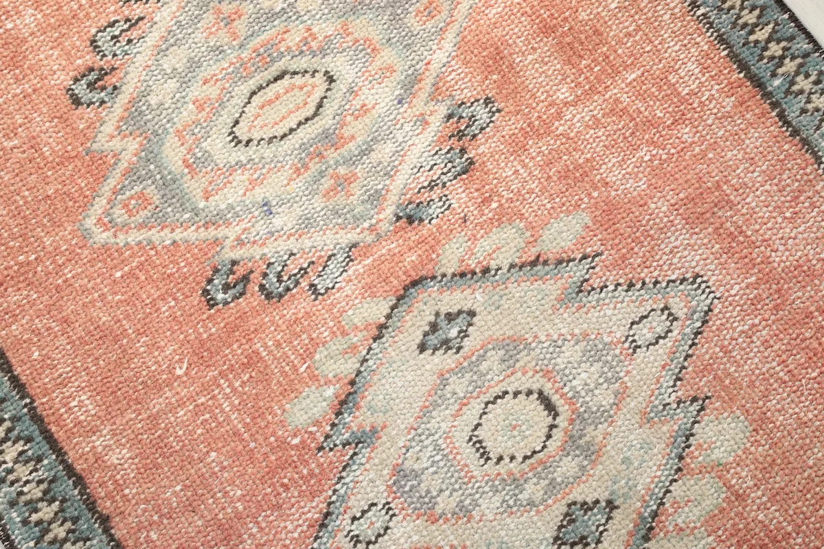 Detailed close-up of the geometric motifs and the rust color variation in the pile