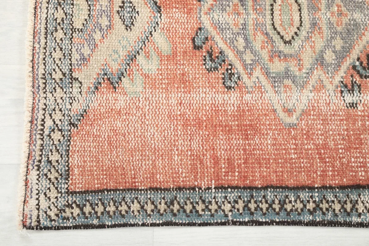 Close-up of the rug's border design and corner with subtle fringe details
