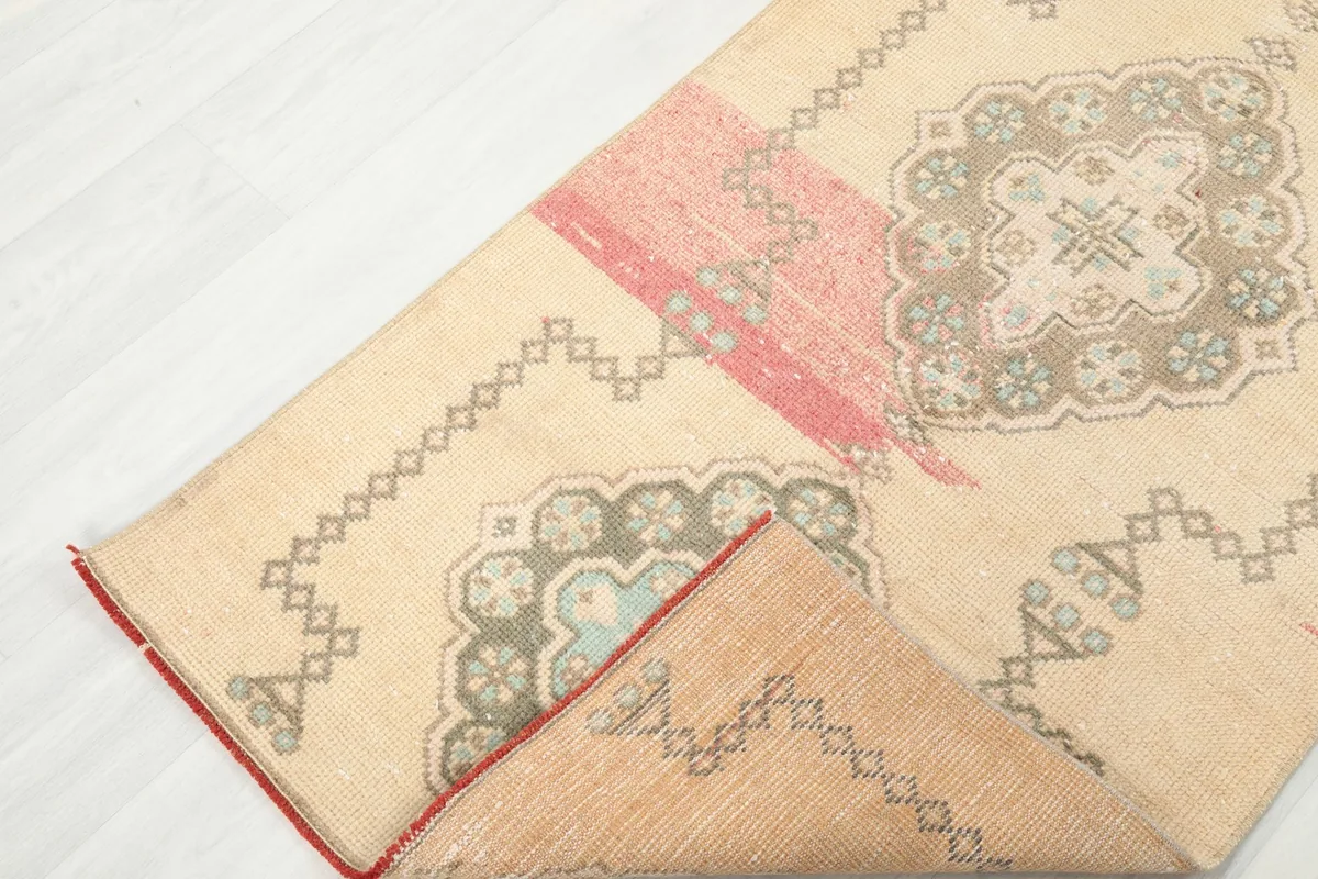 View of the runner rug folded back to show the reverse side and the hand-knotted construction.