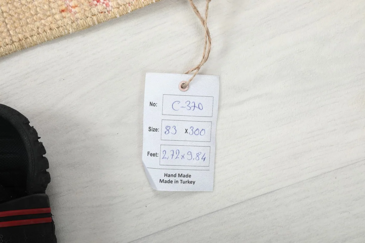 Product tag displaying the rug's size and origin, placed next to a shoe for scale.