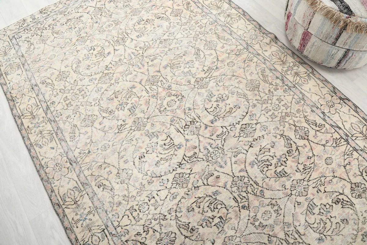 Diagonal view of the ivory rug's surface, showing the subtle color variations and hand-knotted texture.