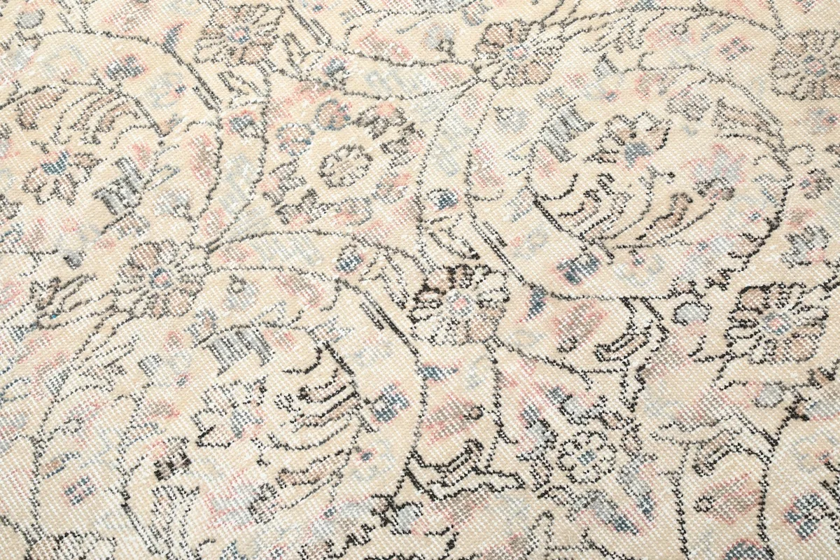 Detailed close-up of the rug's floral patterns and the blend of ivory, blue, and rose colors.