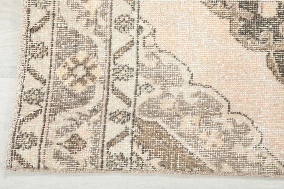 Close-up of the rug's border design and the wear on the wool pile, showing its vintage character