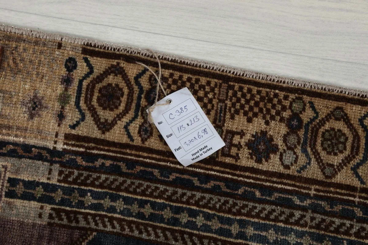 Underside of the rug with a tag, showing the tightly woven cotton foundation and hand-knotted construction.