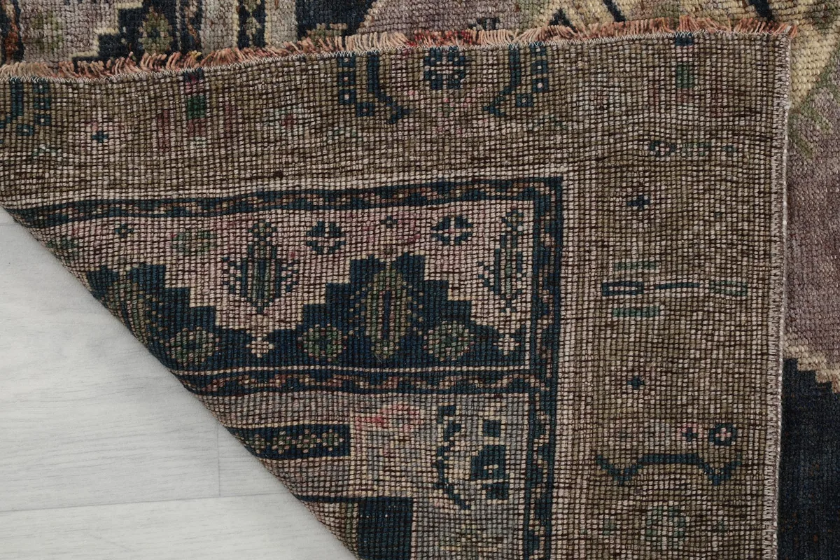 Folded corner of the rug revealing the density of the hand-knotted wool pile and cotton foundation.