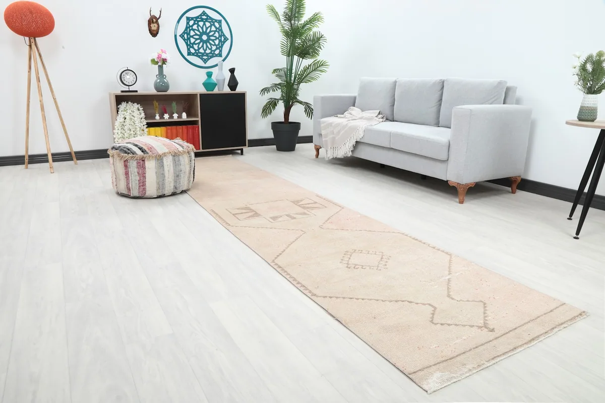 Angled view of the runner rug in a room, showing its length and placement between a sofa and pouf.