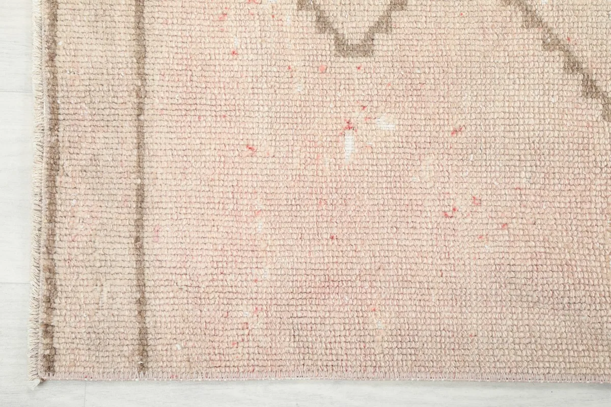 Close-up of a corner of the rug, showing the border detail and the tightly woven wool pile.