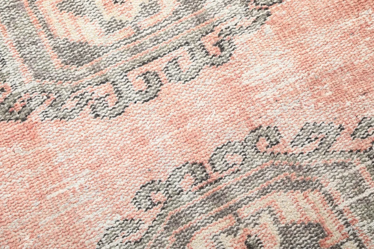Close-up of the low wool pile and the intricate hand-knotted details of the rug's surface.