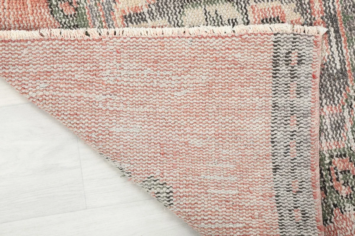 Underside of the hand-knotted wool rug, showing the cotton foundation and construction.