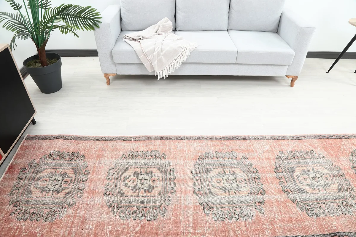 Overhead view of the vintage runner rug, showing multiple gray medallion motifs.