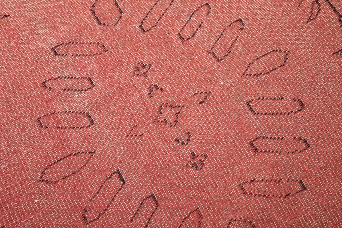 Extreme close-up of the hand-knotted wool pile and detailed charcoal geometric shapes