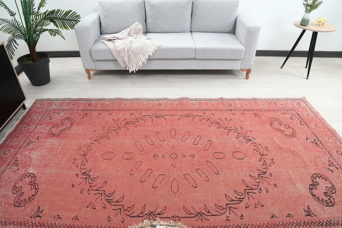 Overhead view of the rose rug in a room, showing its full length and central design