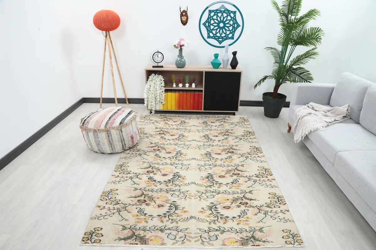 Vintage Anatolian rug displayed in a living room setting with a light gray sofa and wooden furniture