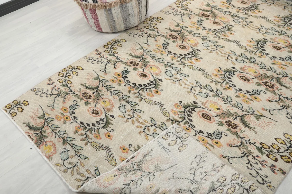 Corner of the rug folded back to show the cotton foundation and the reverse side of the pattern