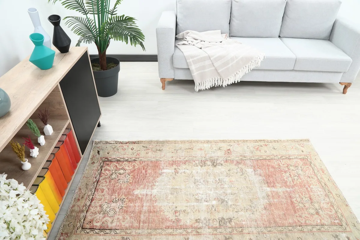 Overhead angle shot highlighting the rug's central medallion and distressed appearance in a room.
