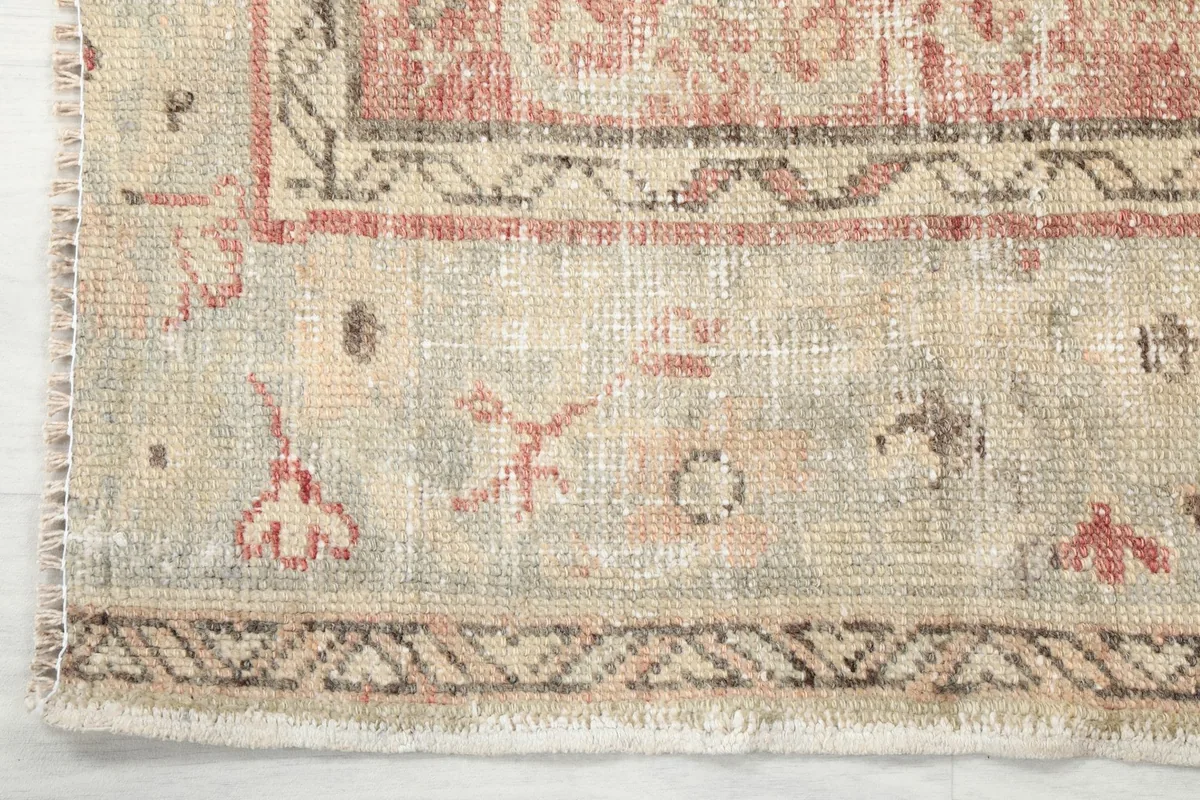 Detailed shot of the rug's border, showcasing the geometric patterns and fringe edge.