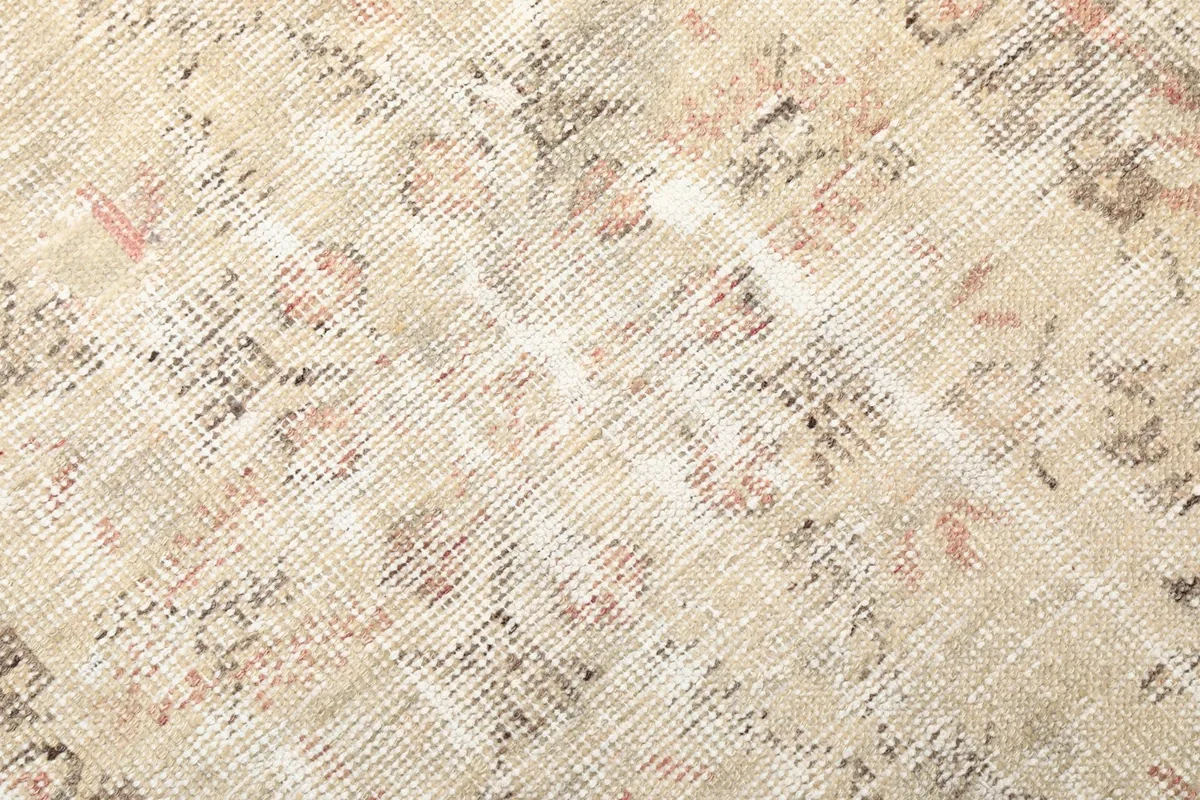 Close-up of the low wool pile, showing the hand-knotted texture and distressed areas.