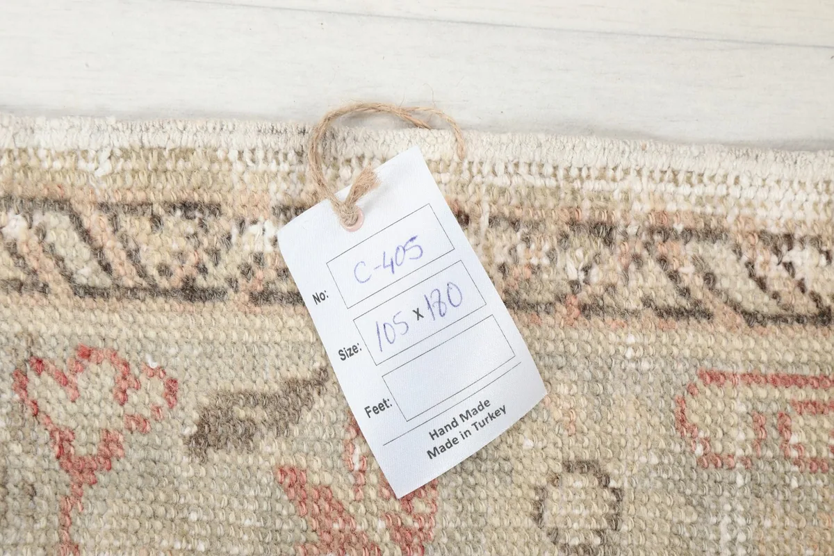 Tag showing the rug's size (105x180 cm) and origin (Hand Made in Turkey) attached to the corner.